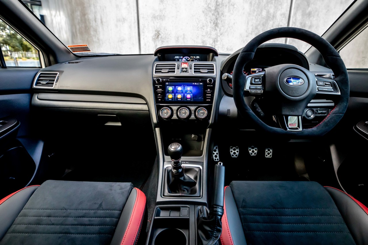 The Subaru SAIGO WRX interior features suede seats with an STI logo and Harman Kardon audio. 