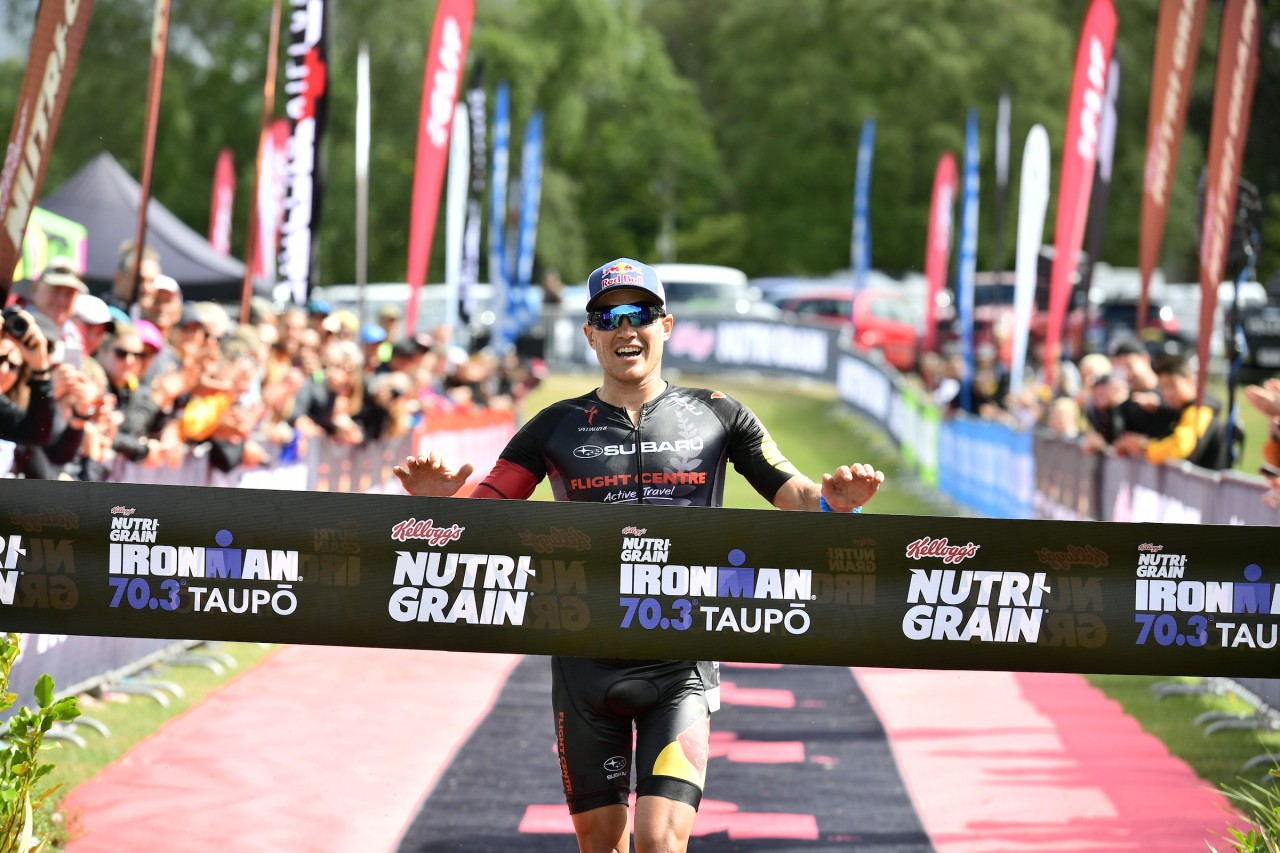 Subaru of New Zealand Brand Ambassador Braden Currie, of Wanaka, grabs the winner’s tape at the finish line of the Kellogg’s Nutri-Grain IRONMAN 70.3 Taupo title yesterday. PHOTO CREDIT: DARRYL CAREY